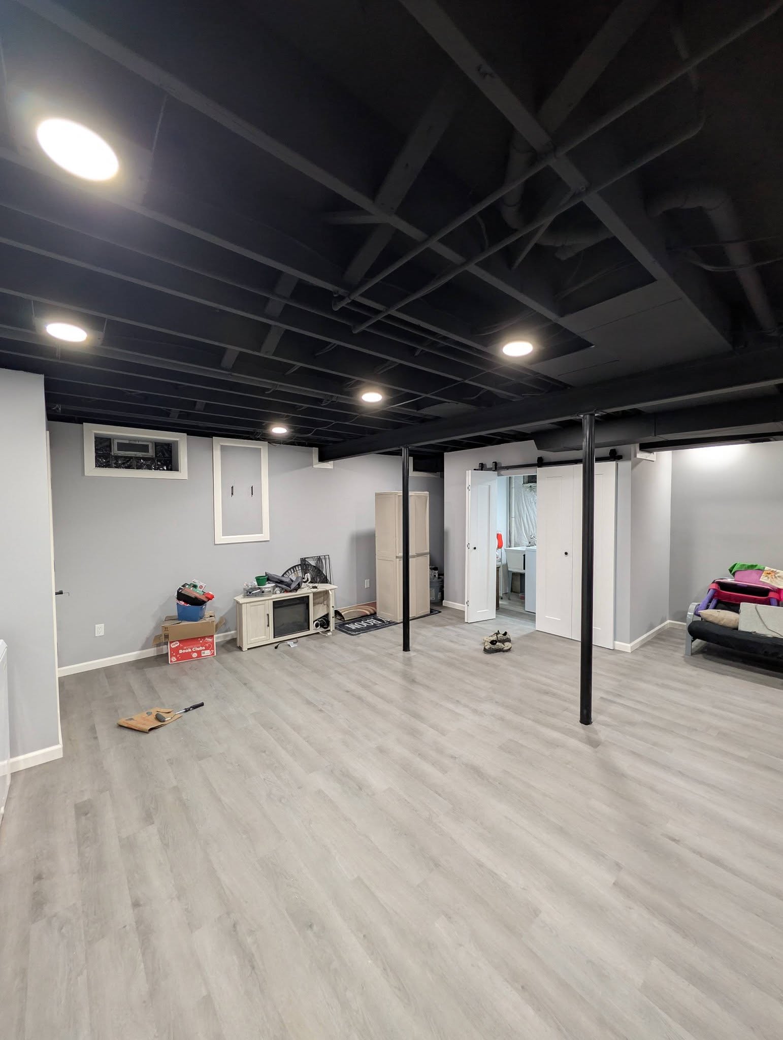 Finished basement with black painted ceiling and LVP flooring