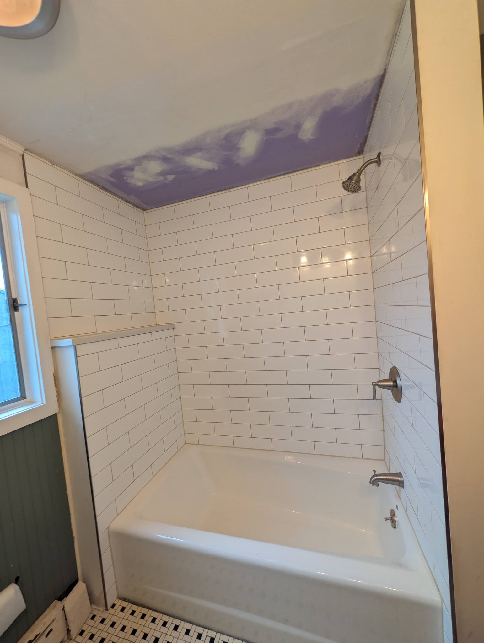 Bathroom remodel with white tile tub and shower surround