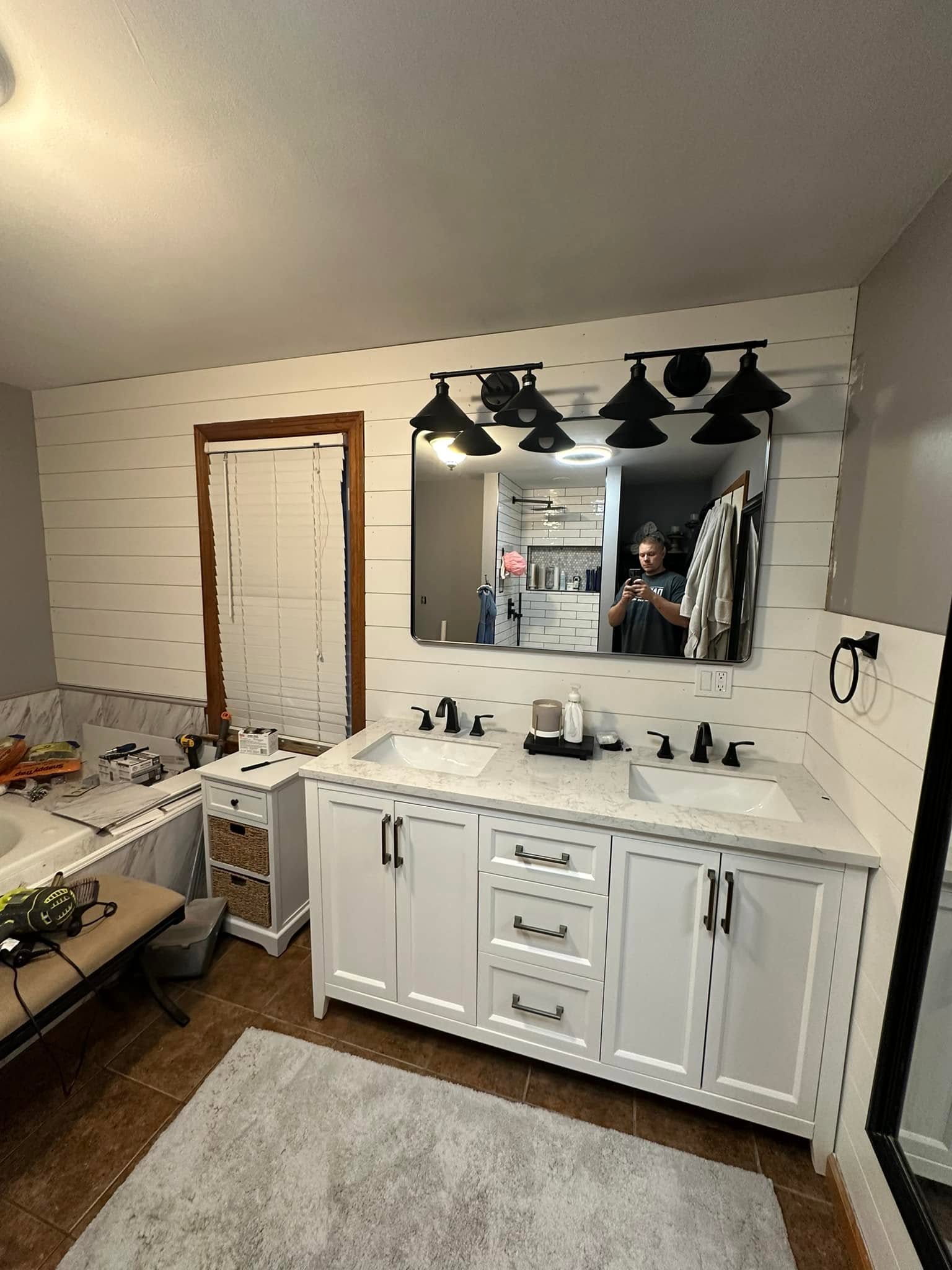 Bathroom remodel with white double vanity and shiplap wall