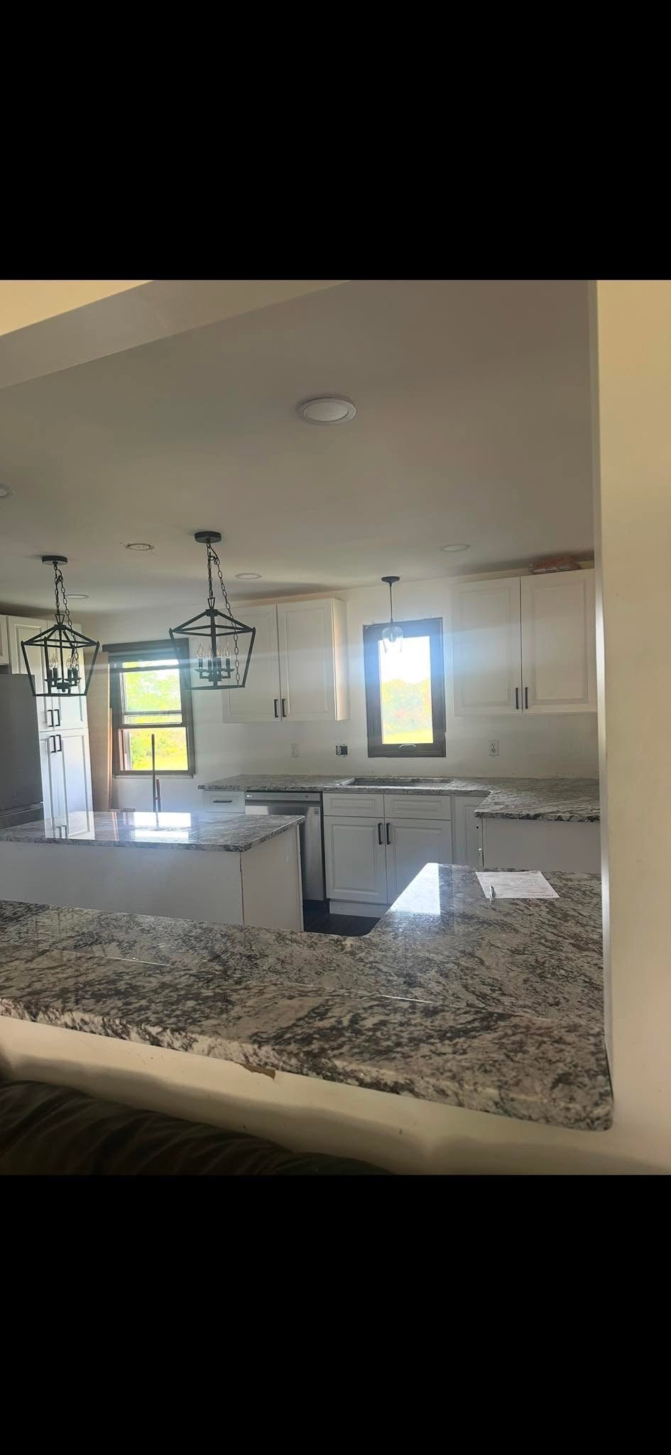 Kitchen remodel with granite island countertop and lantern pendants