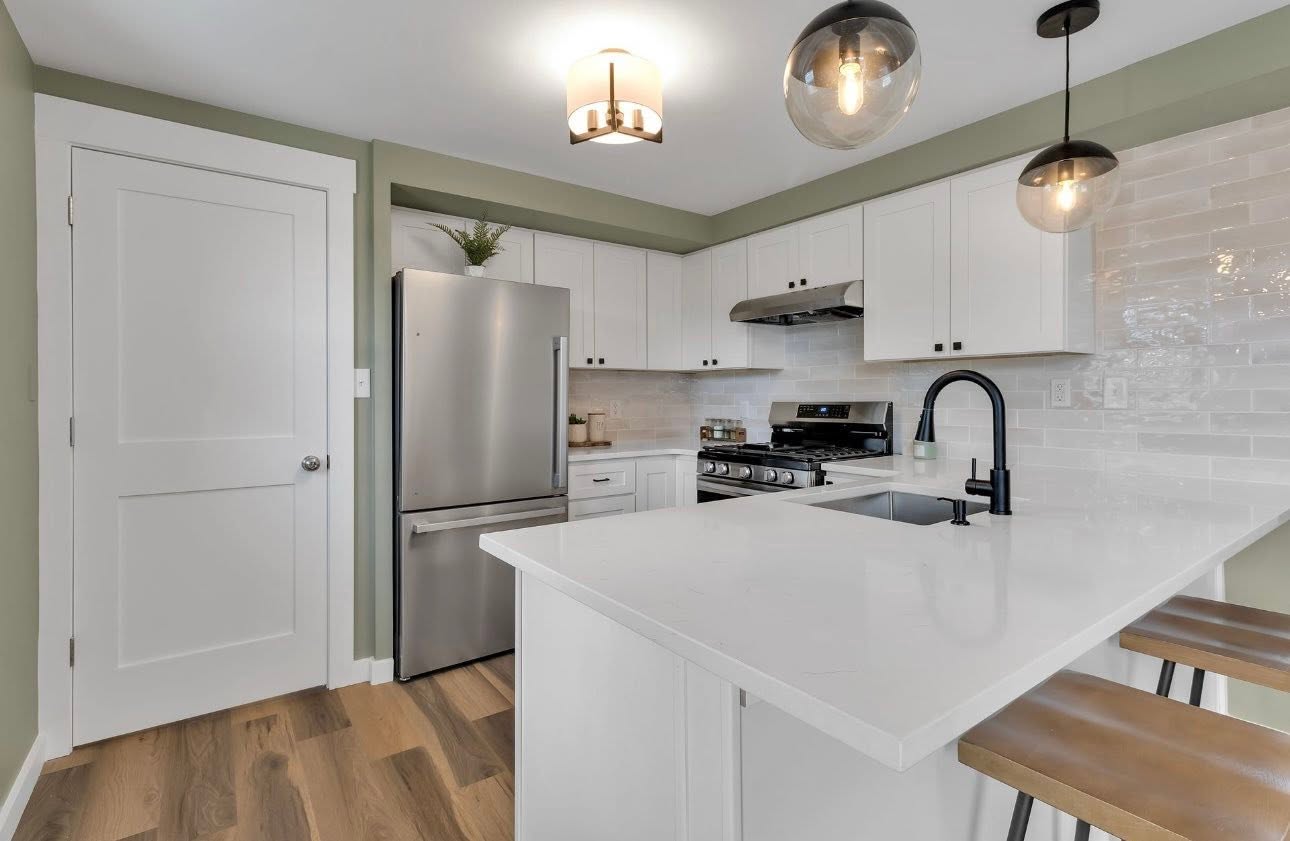 Finished kitchen remodel with white cabinets and quartz island